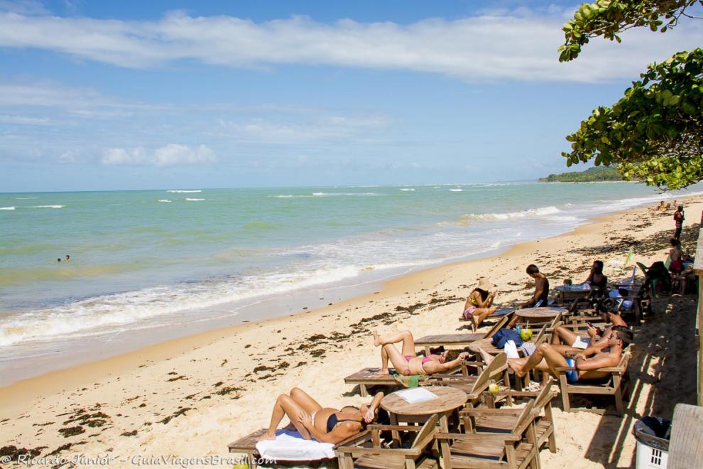 Imagem de pessoas nas espreguiçadeira na linda Praia de Araçaípe.